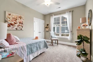 Cozy modern bedroom with pastel bedding, natural light, and soft neutral décor.