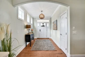 Bright modern home entryway with natural light, wood floors, and elegant neutral decor.