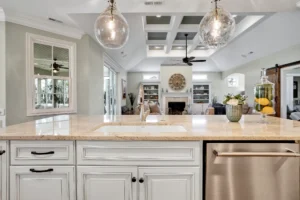 Bright open-concept kitchen and living room with large granite island and elegant modern design.