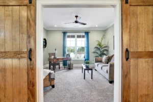 Bright modern farmhouse living room with rustic barn doors, cozy seating, and natural light.