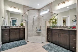 Modern master bathroom with frameless glass shower, dual vanities, and elegant contemporary design.