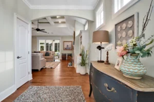 Bright open-concept hallway leading to elegant living room with wood flooring and natural light.