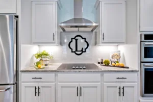 Modern white kitchen with granite countertops, stainless steel appliances, and fresh lemon and plant accents.