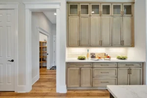Bright modern farmhouse kitchen with light wood cabinets, white countertops, and warm hardwood floors.