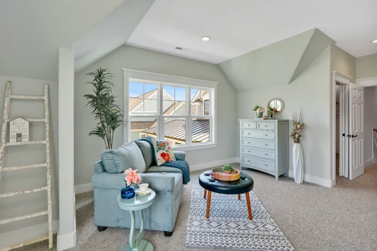 Bright cozy attic reading nook with light blue sofa, natural light, and calming pastel decor.