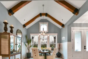 Bright modern farmhouse dining room with wood beams, round table, and large garden doors.