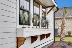 Modern farmhouse exterior with white siding, black windows, and natural wood awning accents.