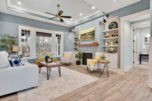 Bright open-concept living room with light blue walls, cozy fireplace, and modern classic decor.