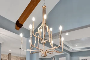Elegant gold chandelier with candle lights hanging in a modern farmhouse-style interior.