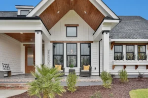 Modern white farmhouse with black trim, wood accents, and a welcoming front porch.