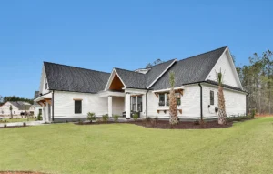Exterior view of The Duval-03 modern farmhouse with white siding, black windows, and charcoal roof.