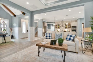 Bright modern farmhouse living room with beige sofa, rustic coffee table, and white open kitchen.