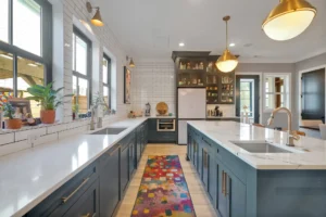 Modern navy and white kitchen with quartz island, gold accents, and pendant lighting.