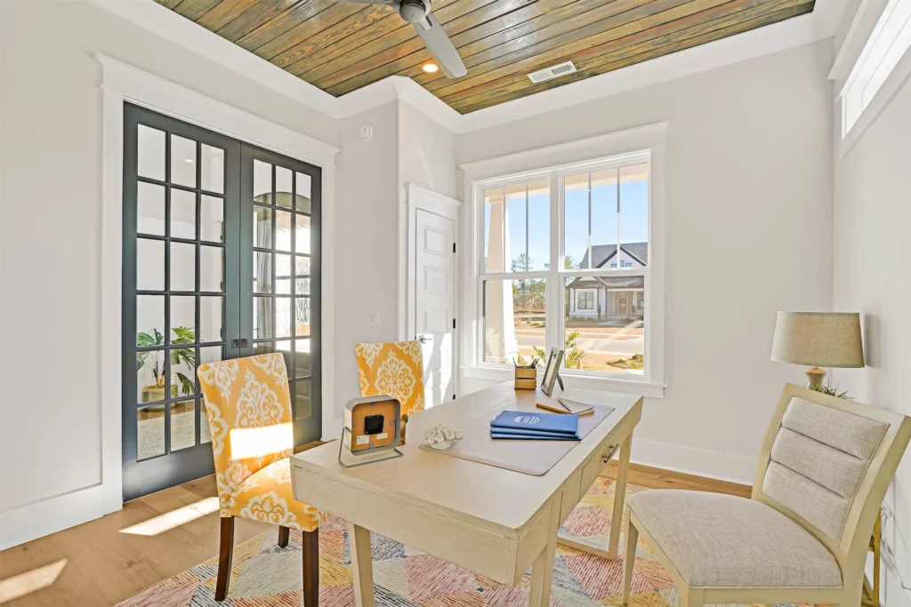 Bright modern home office with natural light, wooden ceiling, stylish chairs, and sunny suburban view.