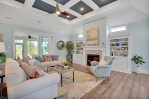 Airy coastal living room with white coffered ceiling, navy accents, fireplace, and modern decor.