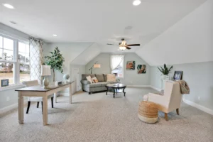 Bright loft living room with gray sectional, blue walls, and cozy reading nook with plants.