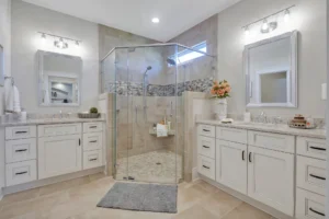 Elegant modern bathroom with frameless glass shower, white vanities, and light tile flooring.