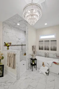 Elegant marble bathroom with walk-in shower, freestanding tub, and crystal chandelier.