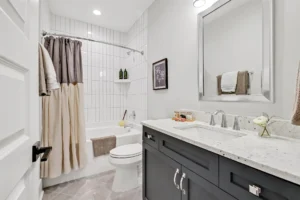 Modern gray and white bathroom with sleek vanity, tiled shower, and elegant contemporary design.