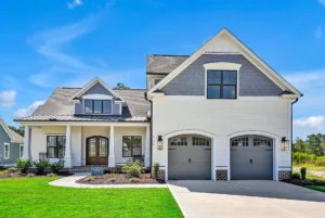 Modern white farmhouse with gray roof, front porch, double doors, and two-car garage.