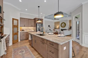 Modern open-concept kitchen with granite island, warm wood cabinetry, and stylish pendant lighting.