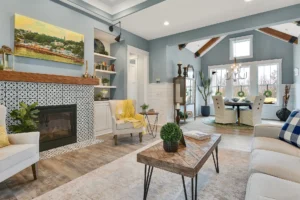Elegant open-concept living and dining room with fireplace, neutral decor, and natural light.