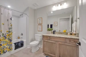 Modern beige bathroom with floral accents, wood vanity, and bright natural decor.