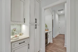 Bright hallway with off-white cabinets, hardwood floors, and elegant modern home design details.