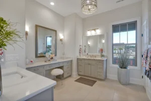 Elegant modern master bathroom with marble vanities, neutral tones, and natural light.