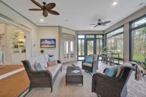 Bright coastal sunroom with wicker furniture, large windows, and natural light for relaxing ambiance.