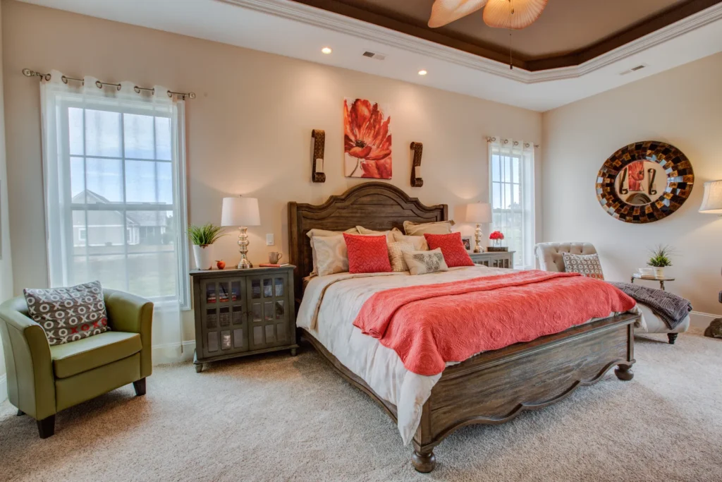 Cozy coral bedroom with carved wooden bed, rustic accents, and warm inviting lighting.