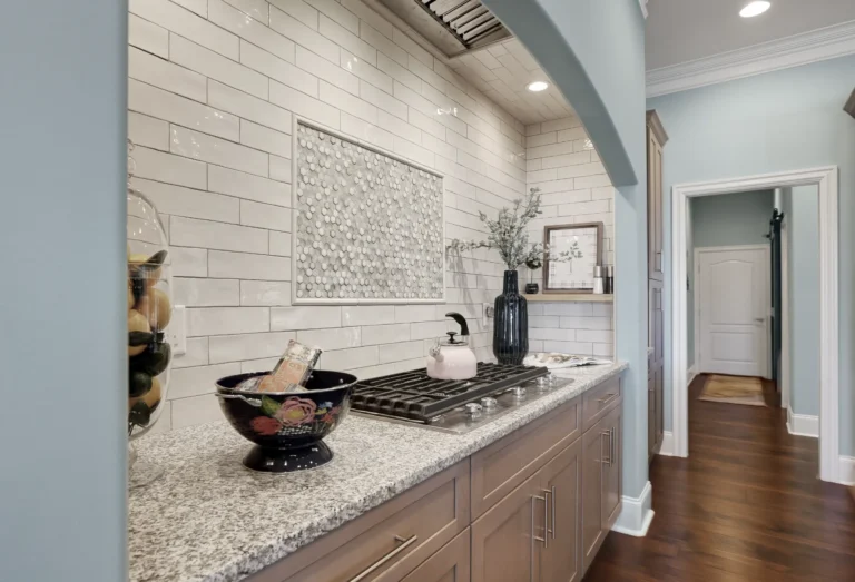 Contemporary kitchen with granite countertops, subway tile backsplash, gas cooktop, and warm wood cabinetry.