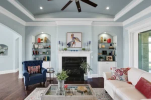 Elegant blue and white living room with fireplace, built-in shelves, and cozy modern décor.