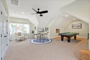 Bright modern attic recreation room with pool table, reading nook, and stylish contemporary décor.