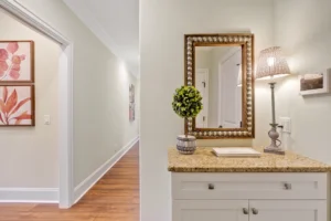 Bright hallway with granite countertop, decorative mirror, and warm modern home décor.