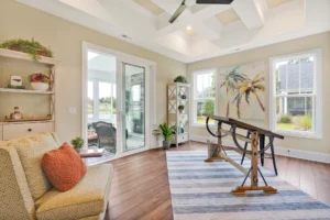 Bright coastal living room with beige walls, wood floors, tropical artwork, and modern beach décor.