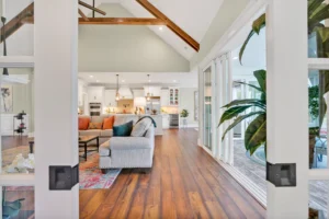 Bright open-concept living room and kitchen with hardwood floors, vaulted ceilings, and natural light.