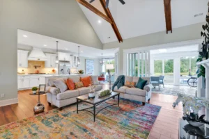 Spacious open-concept living room with vaulted ceilings, modern kitchen, and sunroom filled with natural light.