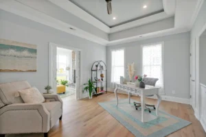 Bright coastal home office with white desk, neutral decor, and natural light-filled elegant design.