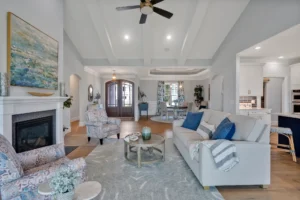 Bright elegant living room with white coffered ceiling, fireplace, and blue-accented neutral décor.